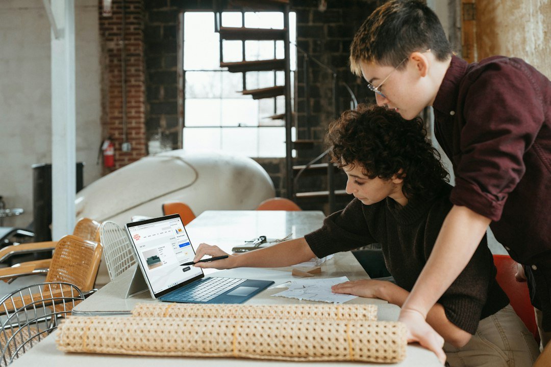 Small business team laptop के साथ AI-enabled workflow पर काम करते हुए